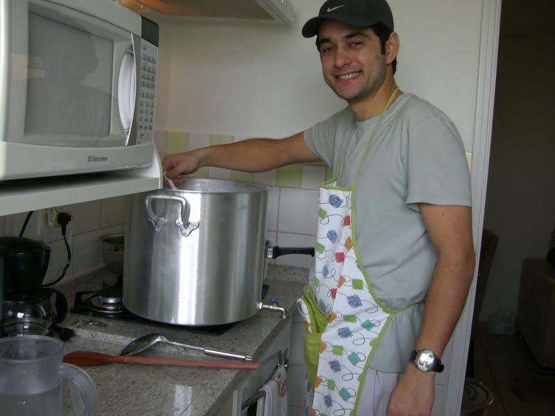 Daniel fazendo cerveja na cozinha do apto