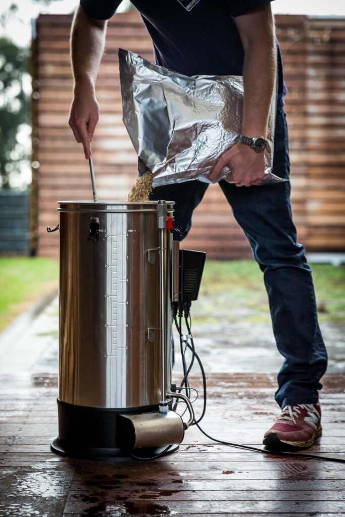 Pesso fazendo cerveja em um kit cervejeiro automatizado